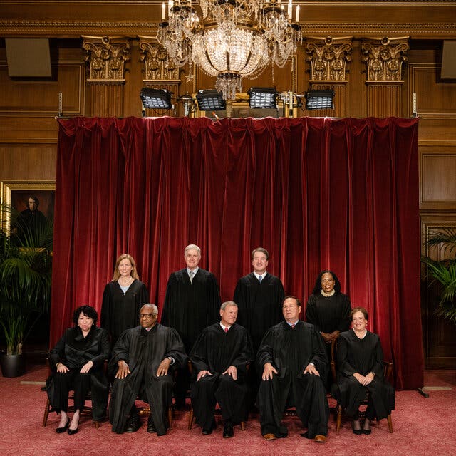 The Supreme Court justices pose in black robes for a portrait.